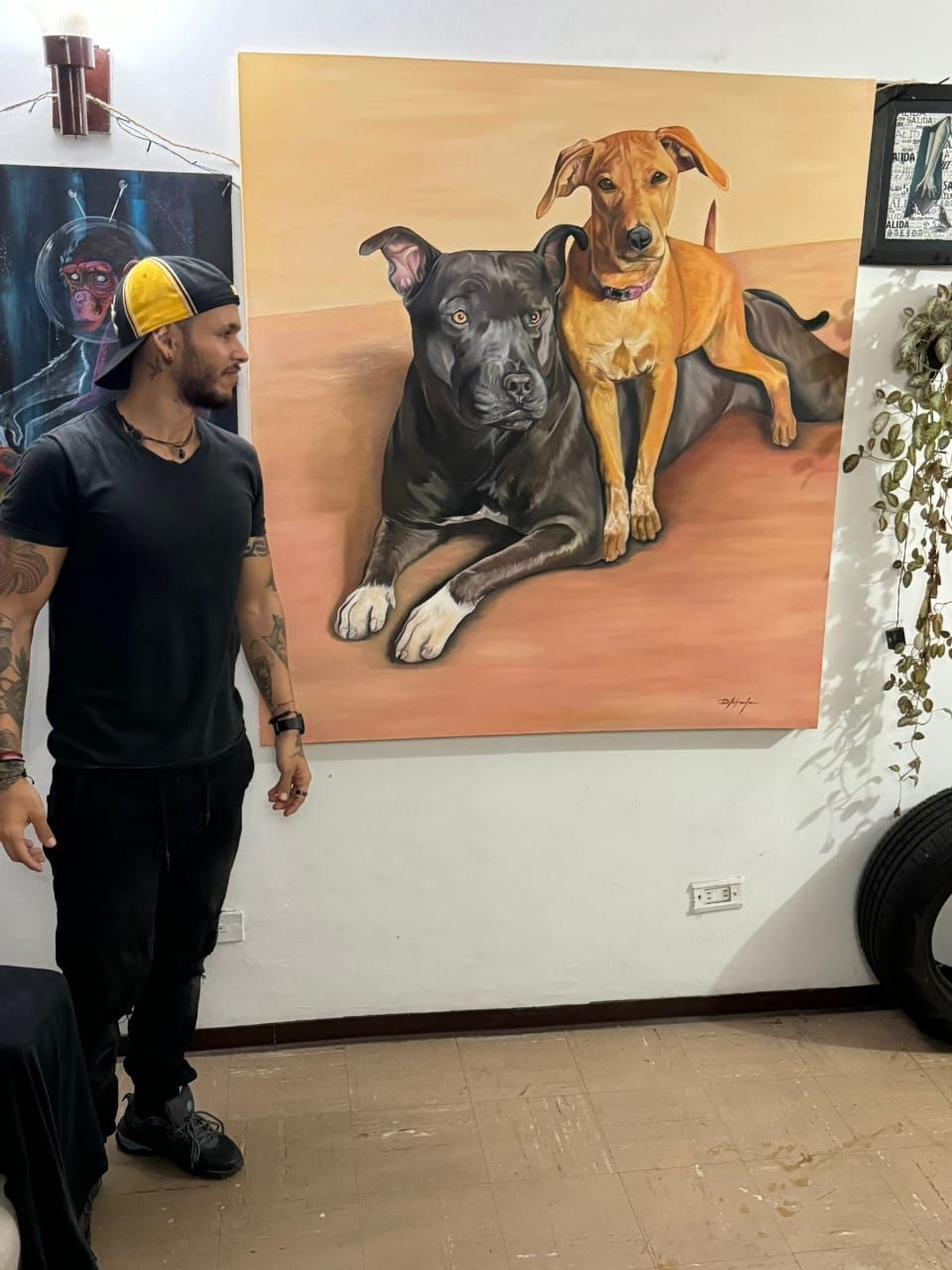 David Naranjo Labrada de pie en su taller junto al retrato «Mi lugar seguro».
